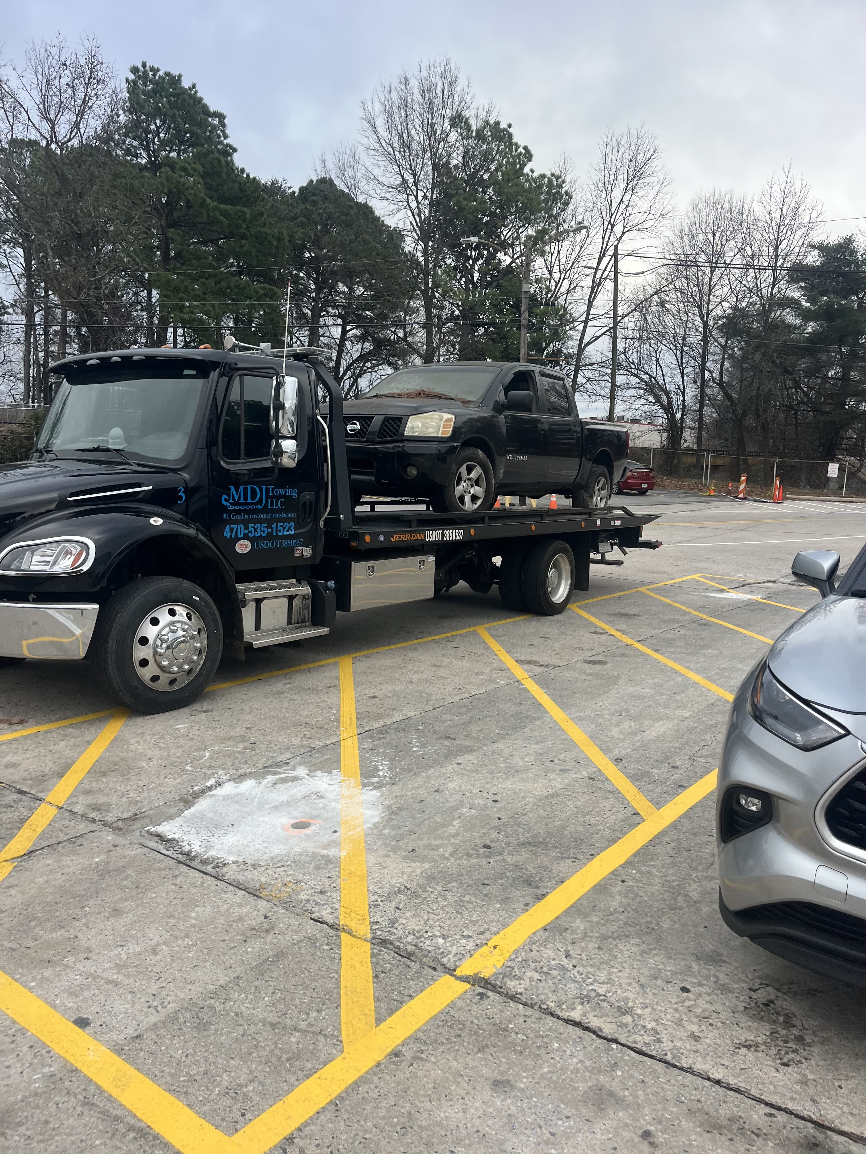 MDJ Towing flatbed truck picking up a junk Nissan truck in Atlanta GA — free towing included