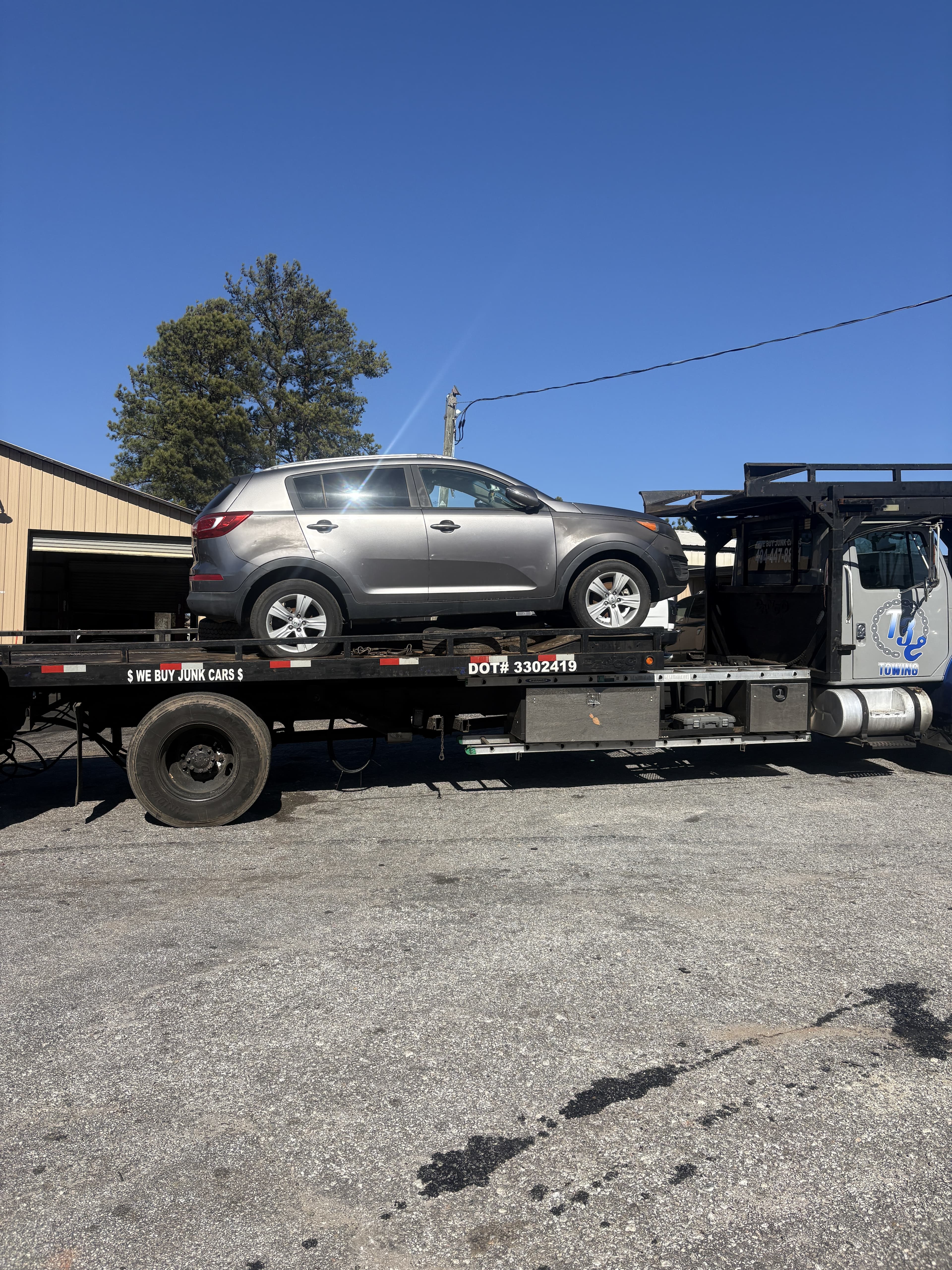 RidOfMyCar flatbed truck picking up a junk car in Atlanta GA — we buy junk cars